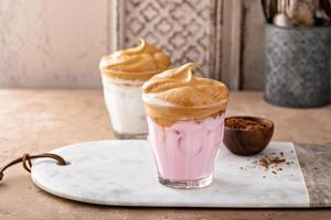 Dalgona whipped coffee with iced strawberry milk in a glass, trendy coffee drink photo