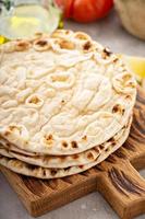 A stack of pita bread on a cutting board photo