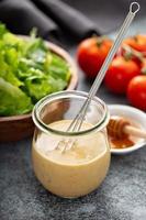 Homemade honey mustard sauce in a glass jar photo