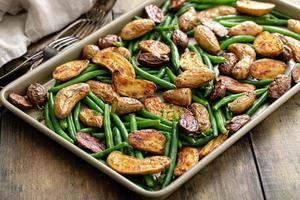 Roasted crispy fingerling potatoes with green beans on a sheet pan photo