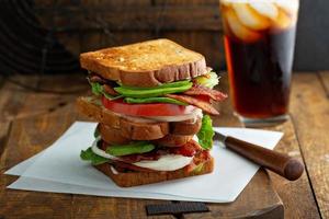 Avocado BLT sandwiches on wooden surface