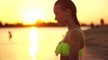 giovane signora nel costume da bagno a tramonto a il caldo sera video