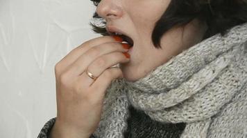 mulher doente com um suéter quente comendo a pílula em casa video