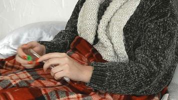 menina doente com um suéter com um termômetro na mão em casa
