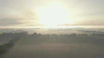 sol nasce sobre um campo coberto de neblina video