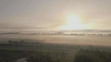 Die Sonne geht über einem nebelverhangenen Feld auf video