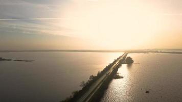 Road extends ahead surrounded by land and water video