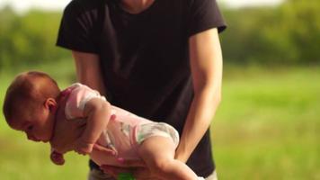young Mom plays with a little baby girl in the woods video