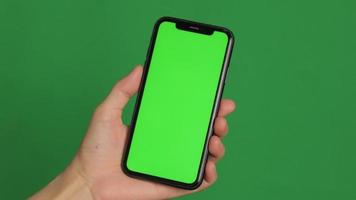 Hand holding a green screen phone. Smartphone in hand video
