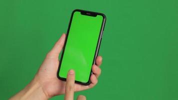 mano sosteniendo un teléfono de pantalla verde. video