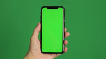 Hand holding green screen phone. Smartphone in hand video