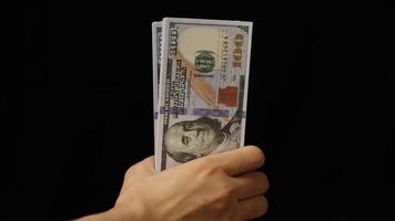 mano que sostiene el billete de un dólar video