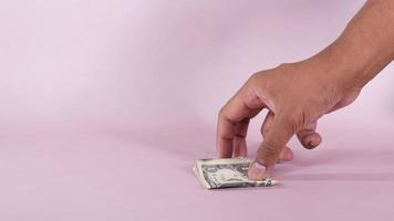 Dólar estadounidense en efectivo en cuero sobre fondo rosa. video