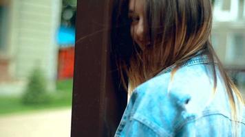 jong blond meisje met rood lippen glimlacht in de straat buitenshuis video