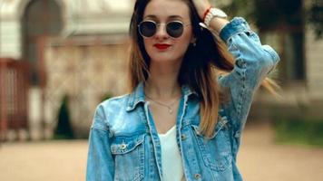 bela jovem loira em óculos de sol redondos e jaqueta jeans video