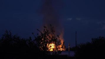la casa de madera está en llamas. fuego en la casa por la noche video
