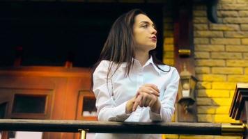 Morena latina de belleza con camisa blanca posando en el porche de la casa video