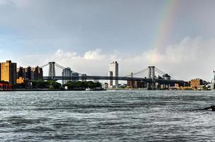 puente de williamsburg que cruza el río este entre brooklyn y manhattan con un arco iris en el fondo. foto