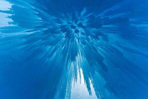 Translucent blue icicles in a frozen ice wall. photo