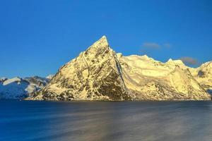 Fishing hut in the Hamnoy and Lilandstinden mountain peak in winter in Reine, Lofoten Islands, Norway. photo