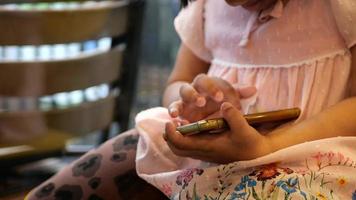 Close up of child girl using smart phone on table video