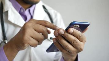 medico in camice bianco utilizzando uno smartphone video