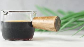 pouring soy sauce in a container with leaf on white background video