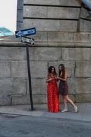dos chicas perdidas interactuando con un teléfono móvil para obtener direcciones en la ciudad de nueva york foto