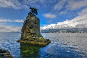 Siwash Rock, also known by Squamish name Skaish, a famous rock outcropping formation on Stanley Park Seawall Vancouver British Columbia Canada photo