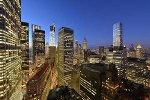 crepúsculo cuando el sol se pone sobre el bajo manhattan. famosos monumentos de nueva york con el hudson y nueva jersey en la distancia. foto