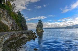 siwash rock, también conocido por el nombre de squamish skaish, una famosa formación de afloramiento rocoso en stanley park seawall vancouver, columbia británica, canadá foto