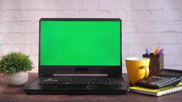 il computer portatile con verde schermo su ufficio scrivania video