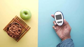 Diabetic measurement tools, almond nuts and apple on table video