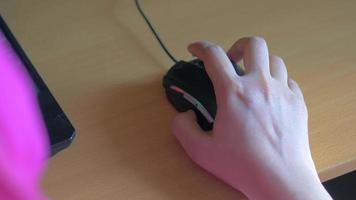 mano de la persona usando el mouse para juegos en la mesa video