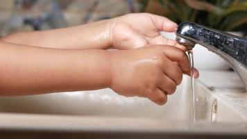 young man washing hands with soap warm water video