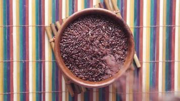 Slow motion of falling red rice in a bowl on table , haradighi rice video
