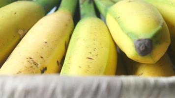 dichtbij omhoog van vers bananen in een kom Aan de tafel video