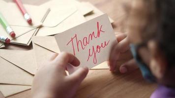 child hand holding thank you letter on table video