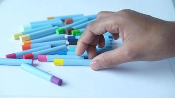 dichtbij omhoog van een kind hand- tekening met gekleurde potlood Aan een bladzijde