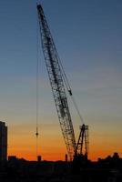 construcción sobre un fondo de una silueta de la ciudad de nueva york al atardecer. foto