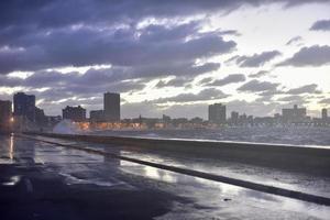 por la noche en el malecón de seaside drive en la habana, cuba, mientras las olas rompen. foto