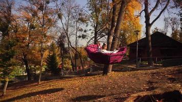 stylish beautiful girl swinging in the autumn park on the street video