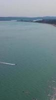 imágenes aéreas de la playa de arena británica y el océano. imágenes verticales y de estilo retrato de 4k de la playa de bournemouth con la cámara de un dron durante la puesta de sol video