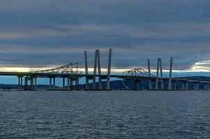 New and Old Tappan Zee Bridges coexisting across Hudson River with a dramatic sunset. photo