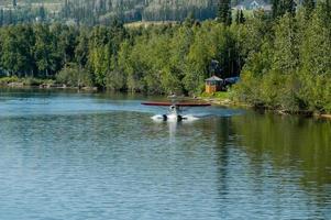 Seaplane landing on the water in Alaska photo