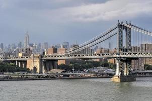 vista del horizonte de nueva york y el puente de manhattan desde el puente de brooklyn en el verano. foto