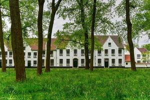 casas blancas medievales en el beaterio principesco begijnhof ten wijngaerde en brujas, bélgica. foto