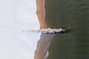 Aerial view of a snow covered Coney Island Beach during the winter at sunrise in Brooklyn, New York photo