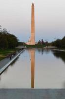 Washington Monument reflecting in the Lincoln Memorial Reflecting Pool at sunset in Washington, DC. photo