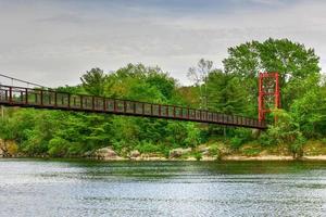 The Androscoggin Swinging Bridge is a pedestrian suspension bridge spanning the Androscoggin River between the Topsham Heights neighborhood of Topsham, Maine and neighboring Brunswick. photo